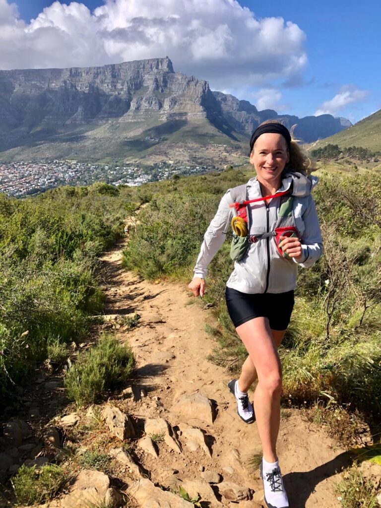 woman trail running on lions head, table mountain, cape town