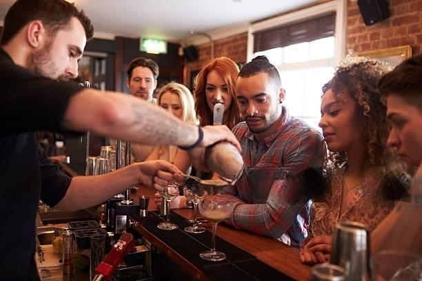 Mixologist mixing cocktails teachinf a class